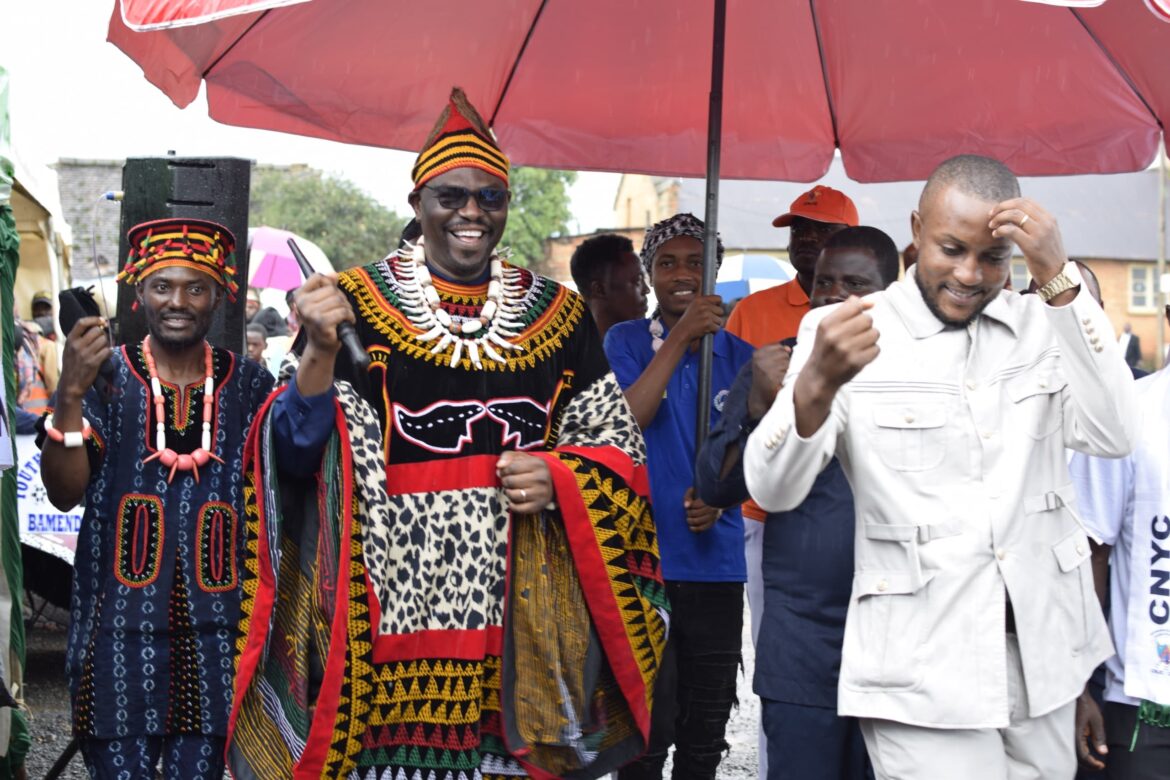 Pioneer nw youth ambassador dr peter taniform, ushered into the ceremonial ground by the nw chapter president of the cameroon national youth council, mekom samuel tale
