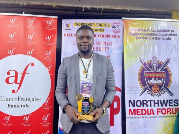 Etienne Nfor Liboh poses for a photo with his award.