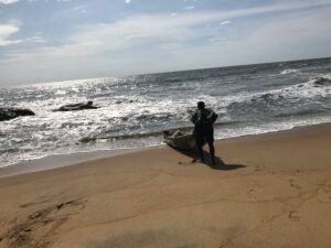 Fisherman with a wooden boast at Ebodje Beach